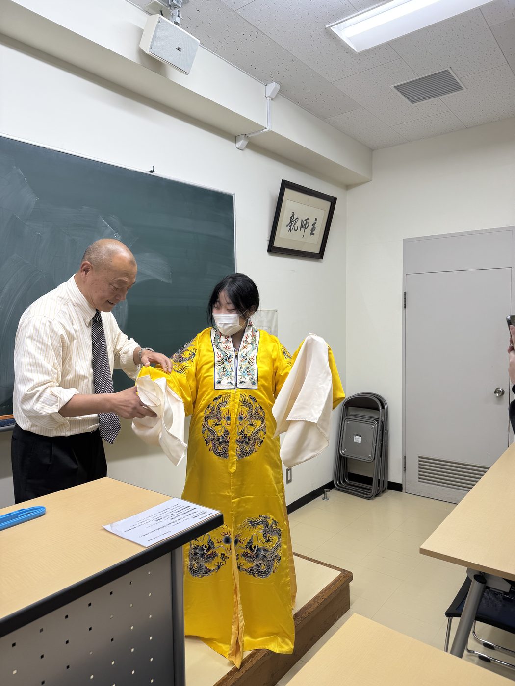 学生が黄色い衣装を試着。