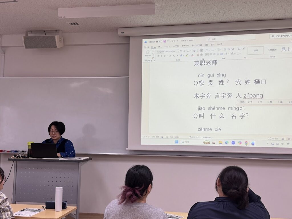 芦田久美子先生の講座の様子（スクリーンに自己紹介の会話の例文）